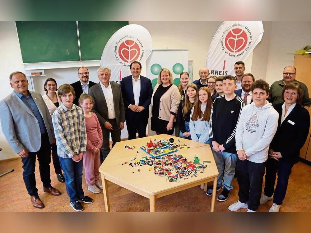 Die Aktiven und Verantwortlichen des Lego-Projekts „Wir bauen ein friedliches Europa“ freuten sich über den Besuch von Minister Nathanael Liminski (7.v.l.) aus Düsseldorf sowie über den Scheck. Foto: Bunte